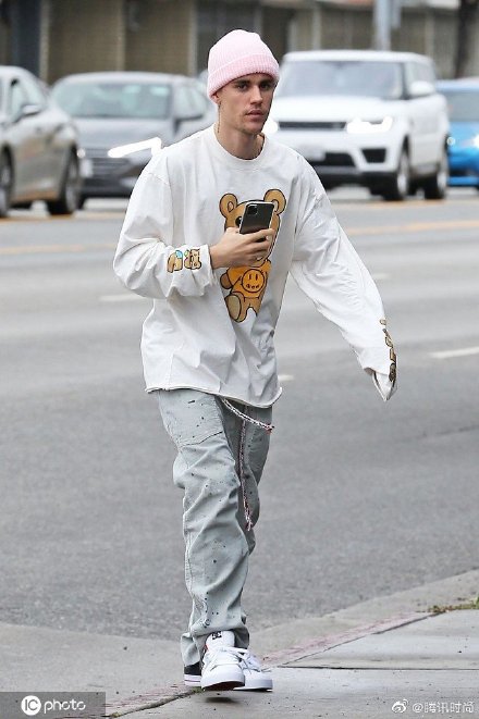 Justin Bieber3月13日在洛杉矶的街拍，他穿着白色卡通长袖TEE戴着粉色绒线帽，一身装扮俏皮可爱-街拍look